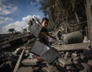 Un niño palestino inspecciona entre los escombros de un edificio destruido tras un ataque aéreo israelí