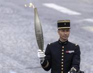 Militar francés sosteniendo la antorcha olímpica.