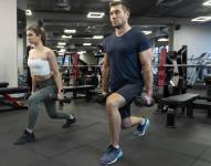 Adultos jóvenes haciendo deporte de interior en el gimnasio.