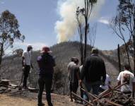 Ciudadanos miran un incendio en el cerro Auqui de Quito