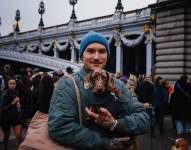 Un hombre lleva un perro salchicha mientras participa en la quinta edición del 'Paris Sausage Walk'