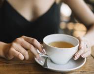 Mujer frente a su taza de té.