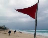 Fotografía de una bandera roja en la playa que indica oleaje agitado y fuertes corrientes debido a la proximidad de la tormenta tropical 'Beryl'.