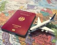 Pasaporte alemán sobre mapa y junto a un avión.