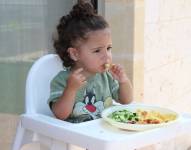 Niña comiendo verduras.