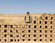 Fotografía de un niño trabajando en un horno de ladrillos.