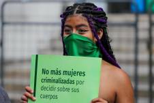 Fotografía de archivo de una joven sostiene que un cartel de protesta durante una concentración de mujeres a favor del derecho al aborto frente a la Corte Constitucional de Ecuador, en Quito.
