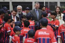 El rey Felipe VI (c) y el Presidente de Ecuador, Daniel Noboa, saludan a niños en la inauguración de una nueva escuela del Atlético de Madrid en Cuenca (Ecuador)