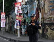 Un policía venezolano custodia una calle junto a pancartas con la imagen del presidente y candidato presidencial venezolano, Nicolás Maduro, en Caracas el 27 de julio de 2024.