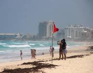 Turistas permanecen en las playas ante el alto oleaje, en el balneario de Cancún, en Quintana Roo (México).
