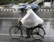 Un hombre en bicicleta durante la intensa lluvia en Nueva Delhi (India)