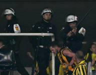 Agentes de la Policía brasileña intentando capturar a un hincha de Peñarol.