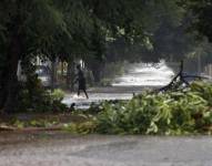 Una persona camina por una calle inundada de La Habana debido al paso del huracán Rafael. EFE/ Ernesto Mastrascusa