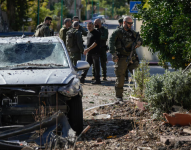 Oficiales de seguridad israelíes y soldados del ejército inspeccionan el lugar donde cayó un cohete disparado desde el Líbano en un patio trasero de Kiryat Shmona, en el norte de Israel, el martes 26 de noviembre de 2024.