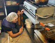 Una inspectora revisa el área de la cocina en el local de comidas.