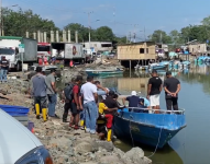 Imagen de transeúntes observando la panga donde tres pescadores fueron asesinadas esta tarde, en Bajo Alto, en El Oro.