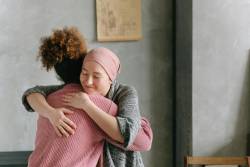 Imagen referencial de mujer con cáncer abrazando a su amiga.