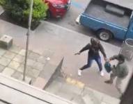 Un hombre forcejea con un delincuente que lleva puesto casco y trata de arrebatarle una mochila. Captura de video