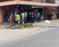 Foto de ciudadanos y policías reunidos ante el asesinato de dos estudiantes en el barrio Las Palmeras del cantón Santa Rosa, de la provincia de El Oro.