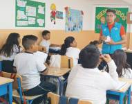 Estudiantes en el salón de clases con su docente.