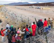 Visto desde una vista aérea, las tropas de la Guardia Nacional de Texas detienen a los inmigrantes que intentan pasar a través de alambre de púas después de cruzar la frontera hacia El Paso, Texas