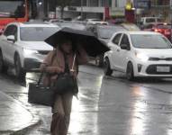 Una mujer en medio de la lluvia en Quito.