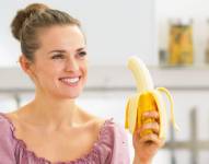 Imagen referencial de mujer comiendo banana.