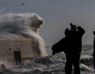 Los residentes observan cómo los fuertes vientos de la tormenta Bert hacen que las olas se estrellen contra el brazo del puerto en Folkestone