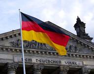 Foto de bandera alemana frente a un edificio.