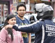 Un agente civil de tránsito atiende las inquietudes de ciudadanos en Quito.