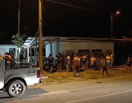 Imagen de personas viendo el trabajo de agentes de Medicina Legal para recoger indicios balísticos tras una matanza