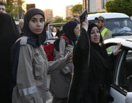 Un miembro de la defensa civil libanesa consuela a una mujer que llegó a Beirut después de huir del sur.