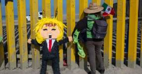 Piñata de Donald Trump junto a una migrante, en la frontera con México.