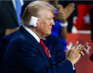 El expresidente Donald Trump cubierto su oreja derecha, la cual fue lastimada por la bala
