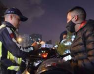 Un agente civil de tránsito durante los controles a un motociclista.