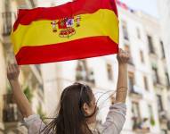 Imagen referencial de mujer sosteniéndo bandera de España.