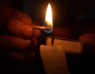 Imagen de un fósforo encendiendo una vela.