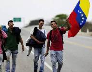 Un grupo de venezolanos caminando en la carretera.