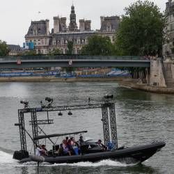 Una lancha con material técnico navega por el río Sena antes del inicio de la ceremonia de inauguración de los Juegos Olímpicos de París 2024
