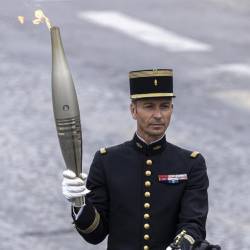 Militar francés sosteniendo la antorcha olímpica.