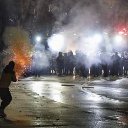 Partidarios de la oposición georgiana lanzan fuegos artificiales hacia la policía durante una protesta frente al edificio del Parlamento en Tbilisi.