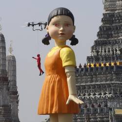 La muñeca más grande del mundo de 'Gokova', de la serie 'El Juego del Calamar' es vista en el río Chao en frente del templo Wat Arun en Bangkok, Tailandia.