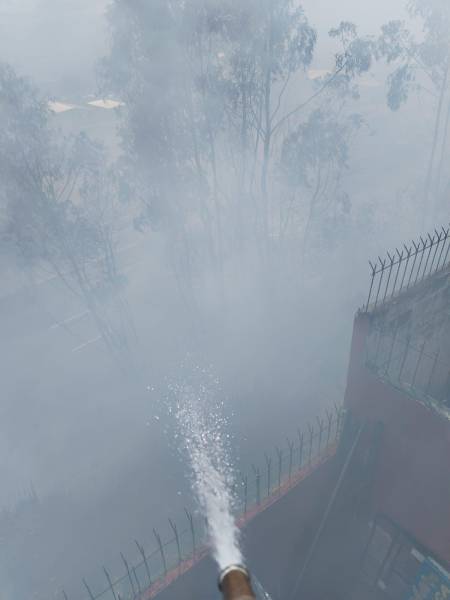 Vecinos usan sus mangueras para controlar el fuego.