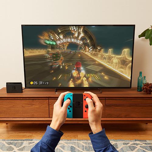 Imagen referencial de adolescente jugando Mario Kart en su Nintendo Switch conectado al televisor.