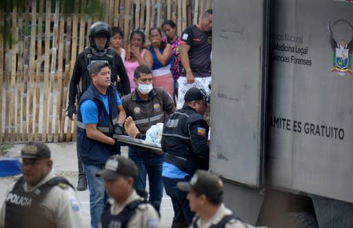 Personal de Medicinal Legal y Ciencias Forenses mueve el cuerpo de uno de los dos hombres abatidos a tiros en Manta, Ecuador, el 5 de junio de 2024.