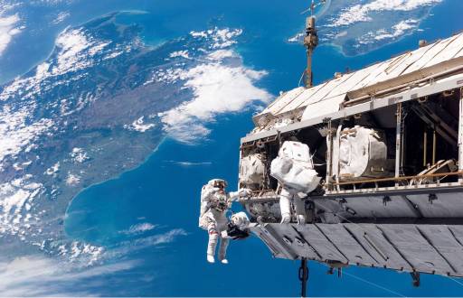 Los astronautas Robert L. Curbeam Jr. y Christer Fuglesang en la Estación Espacial Internacional, con Nueva Zelanda al fondo.