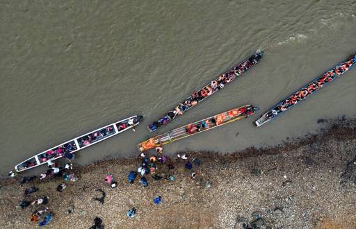 Migrantes se embarcan en canoas para recorrer torrentosos ríos, en su ruta hacia Estados Unidos.