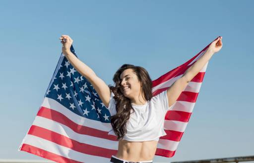 Imagen referencial de mujer sosteniendo la bandera de Estados Unidos.