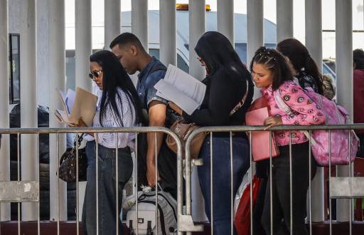 Migrantes hacen fila para solicitar papeles migratorios, este miércoles, en la ciudad de Tijuana, en el estado de Baja California (México).