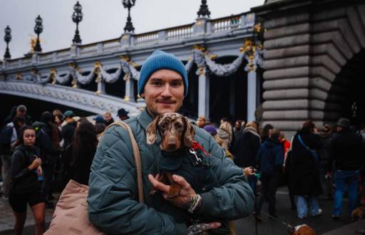 Un hombre lleva un perro salchicha mientras participa en la quinta edición del 'Paris Sausage Walk'